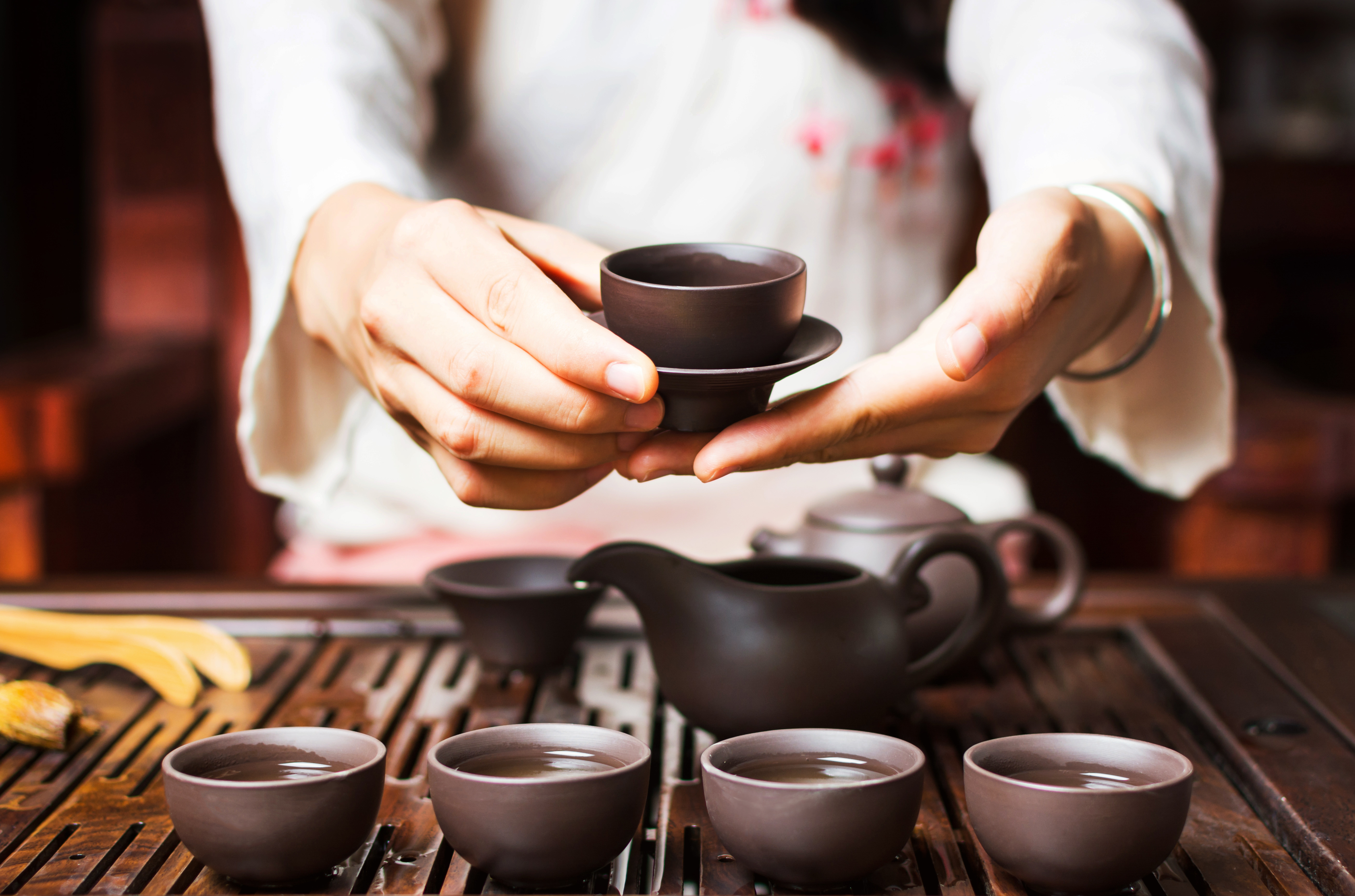 Hands serving tea during traditional Japanese tea ceremony
