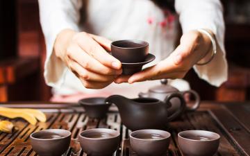 Hands serving tea during traditional Japanese tea ceremony