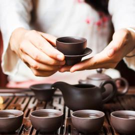 Hands serving tea during traditional Japanese tea ceremony