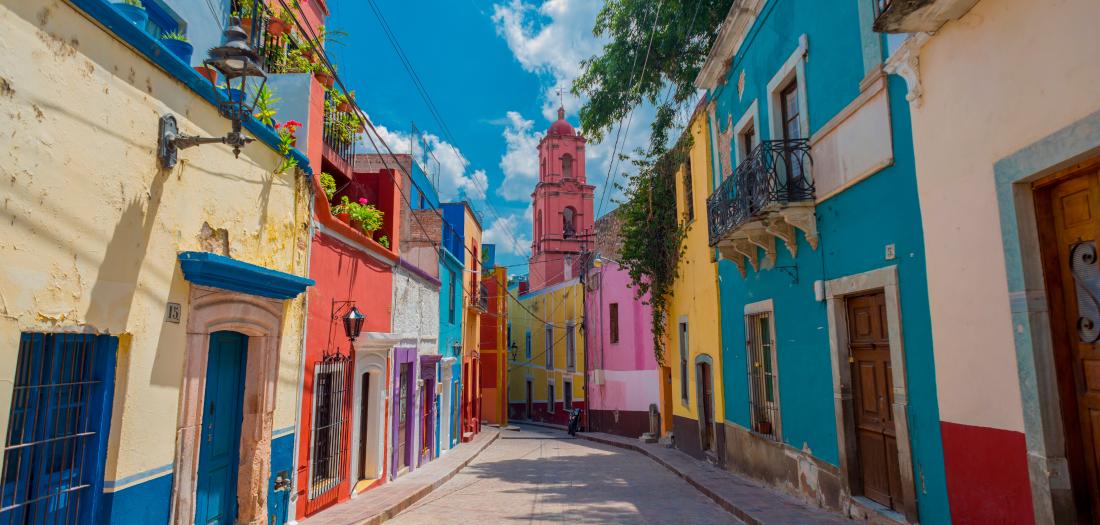 Strada colorata con edifici tradizionali in un centro storico messicano